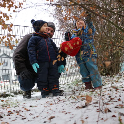 Tagesvater spielt mit den Kindern im Schnee