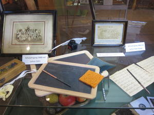 Historische Schulmaterialien wie beispielsweise eine Schiefertafel oder ein Griffel, die im Heimatmuseum Weiskirchen ausgestellt werden.