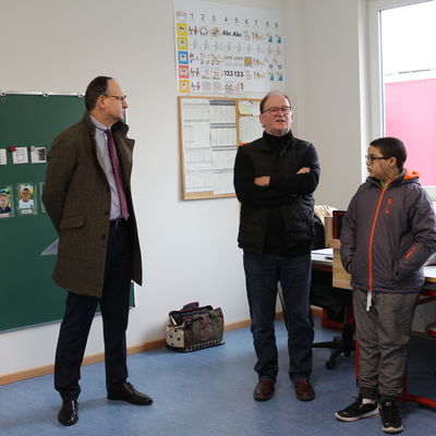 Landrat Oliver Quilling (links) und der Schulleiter der Janusz-Korczak-Schule, Manfred Stich (Mitte) in einem der beiden neuen Klassenrume.