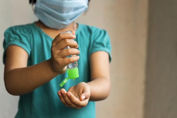 Kind mit Desinfektionsmittel