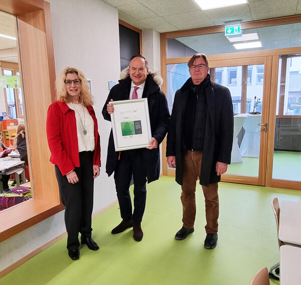 Schulleitern Manuela Mück (links), Landrat Oliver Quilling mit dem Zertifikat über die C02-Bilanz (Mitte) und Leo Hoth (rechts) vom Fachdienst Gebäudewirtschaft des Kreises Offenbach.