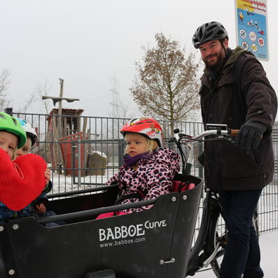 Tagesvater macht gemeinsam mit den Kindern einen Ausflug mit dem Rad
