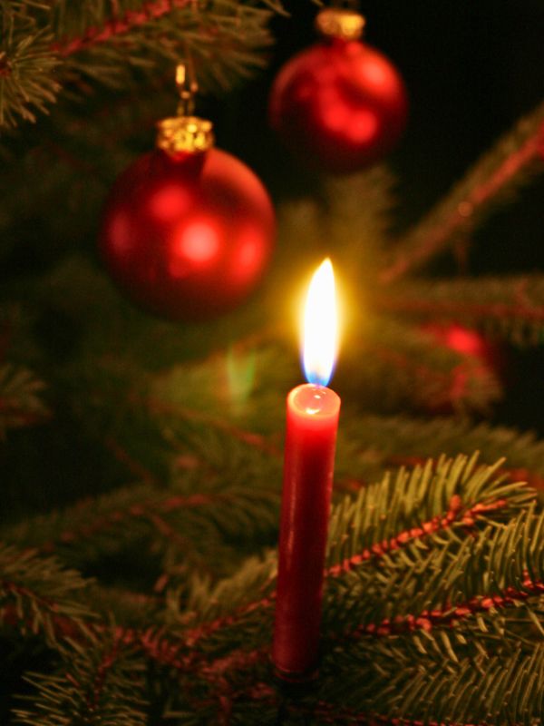 Weihnachtsbaum mit brennender Kerze und Kugeln