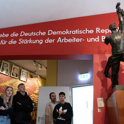Teilnehmende stehen in einem der Ausstellungsräume des DDR Museums.