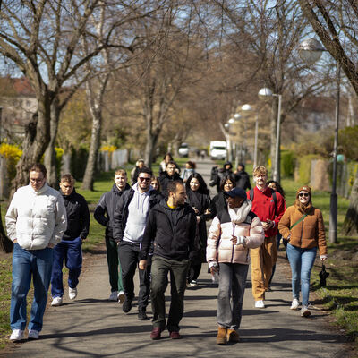 Die Gruppe läuft während der Dekolonialen Stadtführung gemeinsam durch eine Grünanlage.