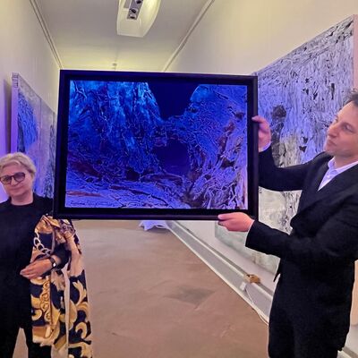 Bild vergr&ouml;&szlig;ern: Kuratorin Dr. Cristina Simion und Künstler Roland Pangrati präsentieren fluoreszierendes Bild